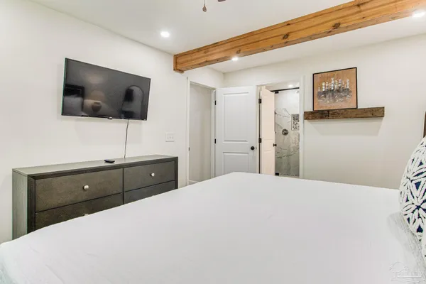 a bedroom with a bed and a flat screen tv