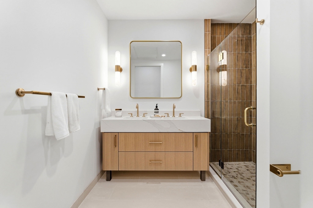 1114 Beacon Street, Unit 207 Newton, MA 02461 - Photo 13 of 29 a bathroom with a sink a mirror and shower
