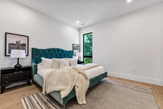 a bedroom with a bed and a lamp on dresser