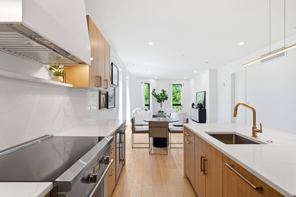 1114 Beacon Street, Unit 207 Newton, MA 02461 - Photo 3 of 29 a kitchen with stainless steel appliances a sink a stove and cabinets