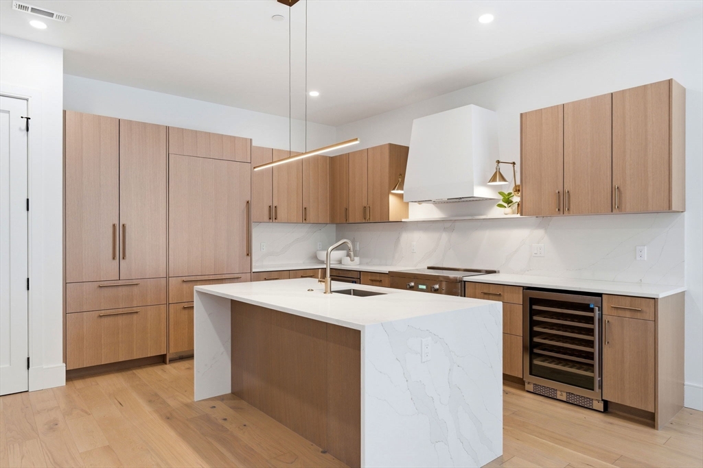 1114 Beacon Street, Unit 207 Newton, MA 02461 - Photo 5 of 29 a kitchen with stainless steel appliances granite countertop a sink stove and refrigerator