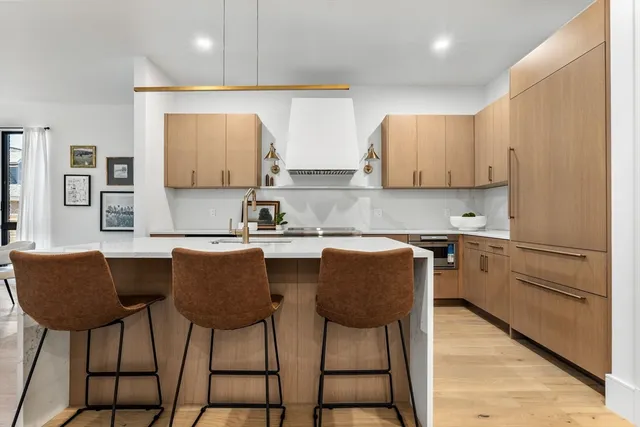 a kitchen with counter top space a sink a stove and cabinets