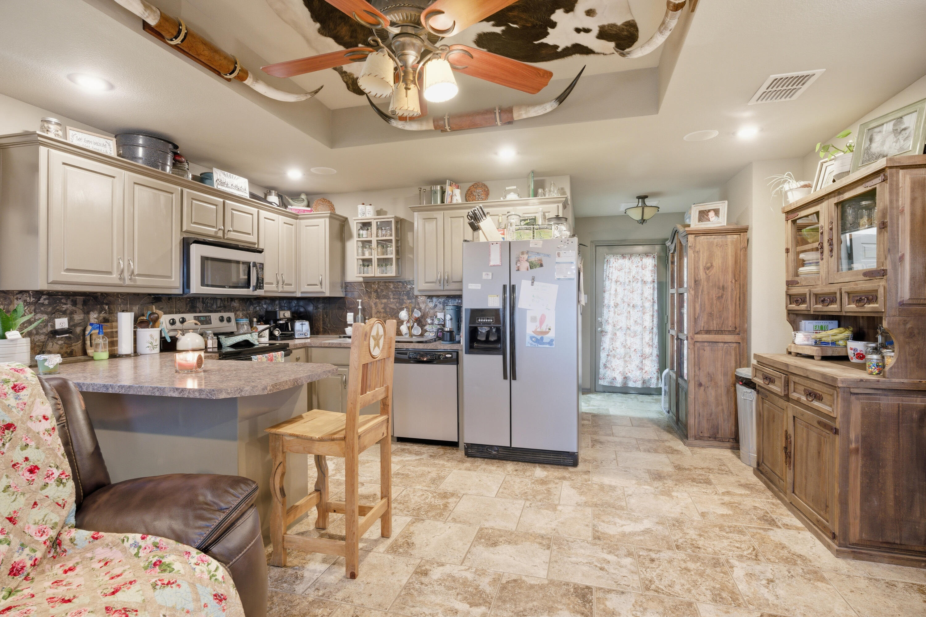 672 Cr M Road New Home, TX 79381 - Photo 20 of 30 a kitchen with stainless steel appliances kitchen island granite countertop a refrigerator and stove