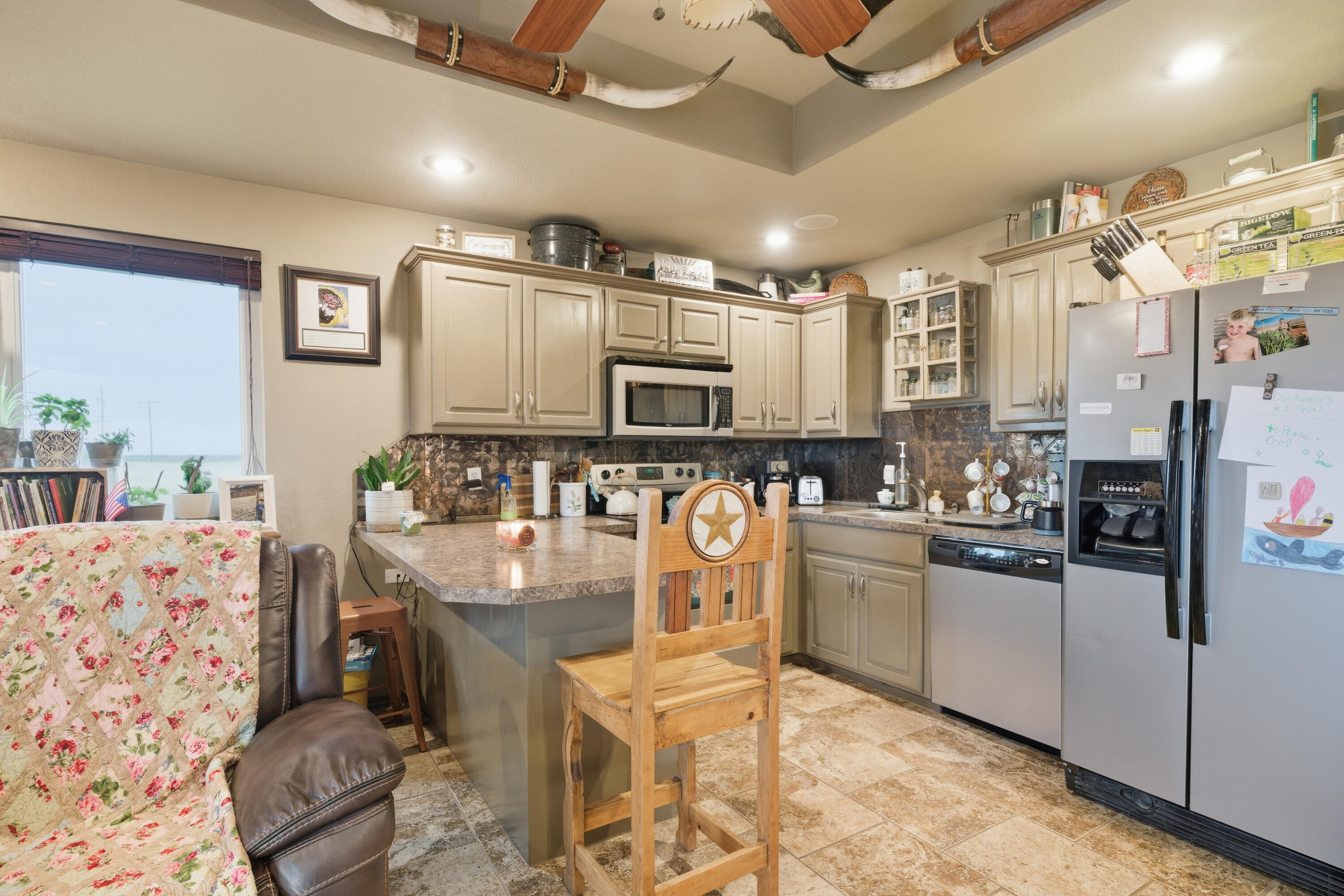 672 Cr M Road New Home, TX 79381 - Photo 21 of 30 a kitchen with stainless steel appliances kitchen island granite countertop a refrigerator and stove