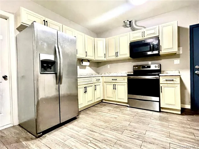a kitchen with stainless steel appliances a refrigerator sink and microwave