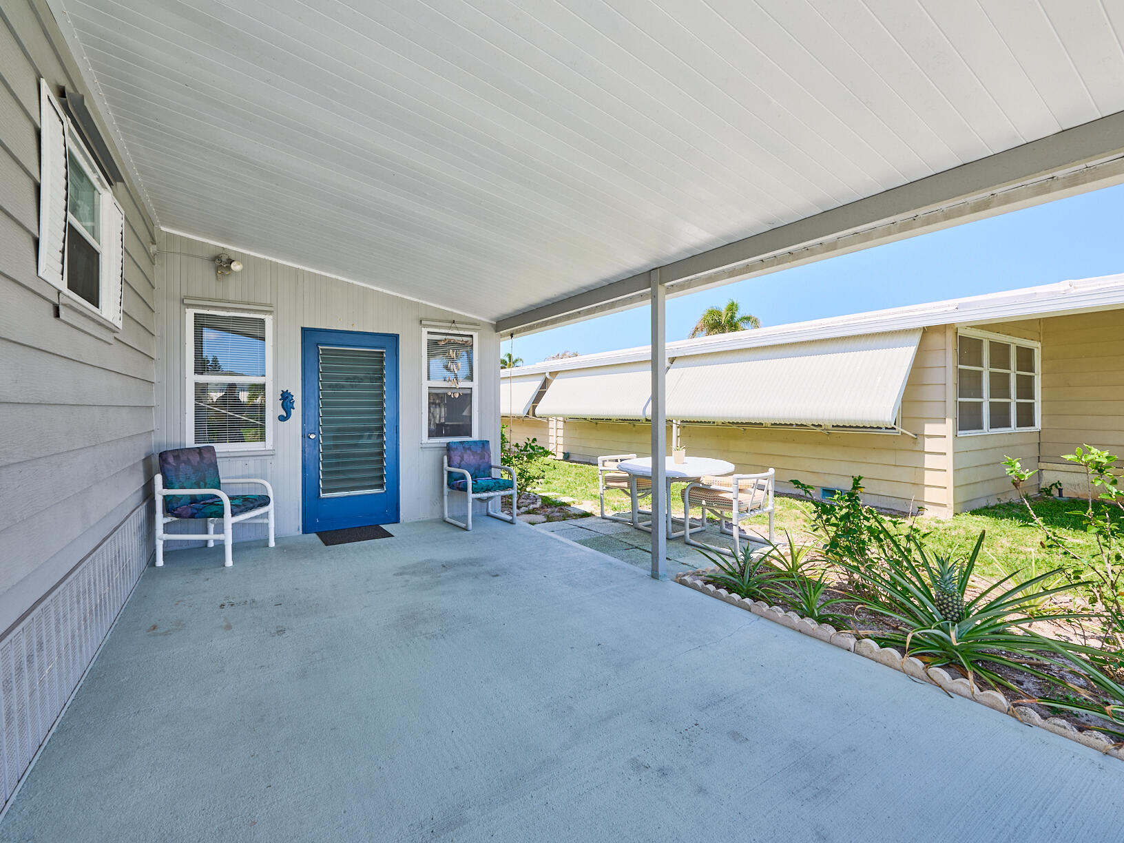 6977 Southeast Delegate Street Hobe Sound, FL 33455 - Photo 9 of 60 a view of a house with a swimming pool and sitting area