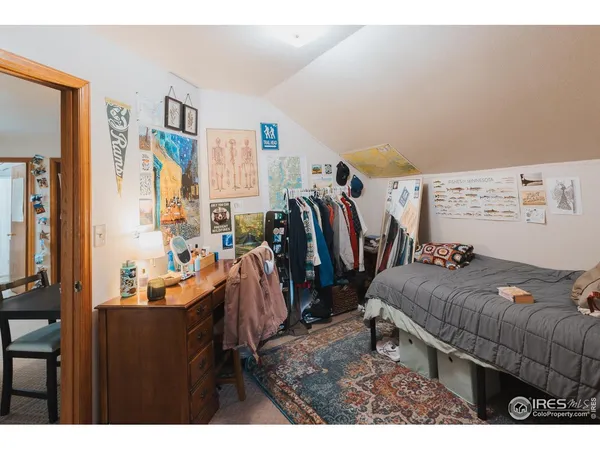 a bedroom with a bed a large window and a flat screen tv