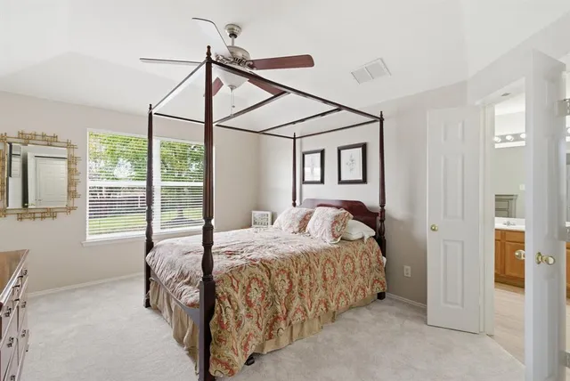 a bed sitting in a bedroom next to a window