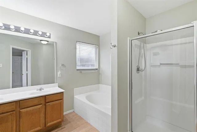 a bathroom with a tub a sink shower and mirror