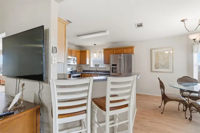 a kitchen with white cabinets and chairs