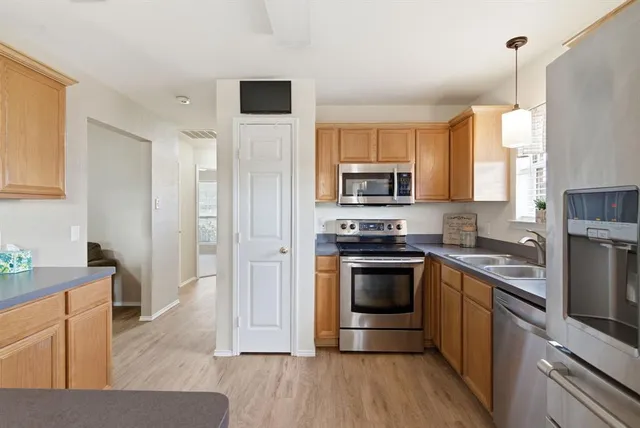 a kitchen with stainless steel appliances granite countertop a stove a sink and a refrigerator