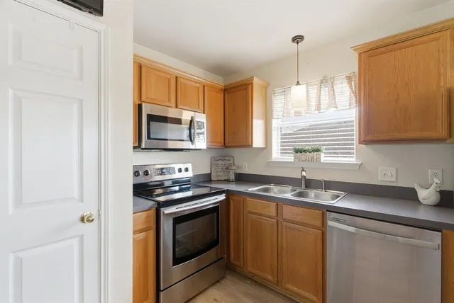 a kitchen with stainless steel appliances granite countertop a sink stove and microwave