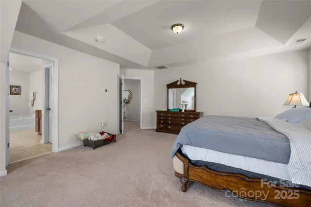 a spacious bedroom with a bed and a chandelier