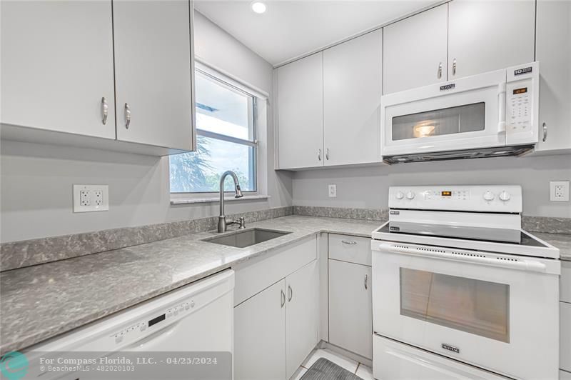 a kitchen with white cabinets appliances and a sink