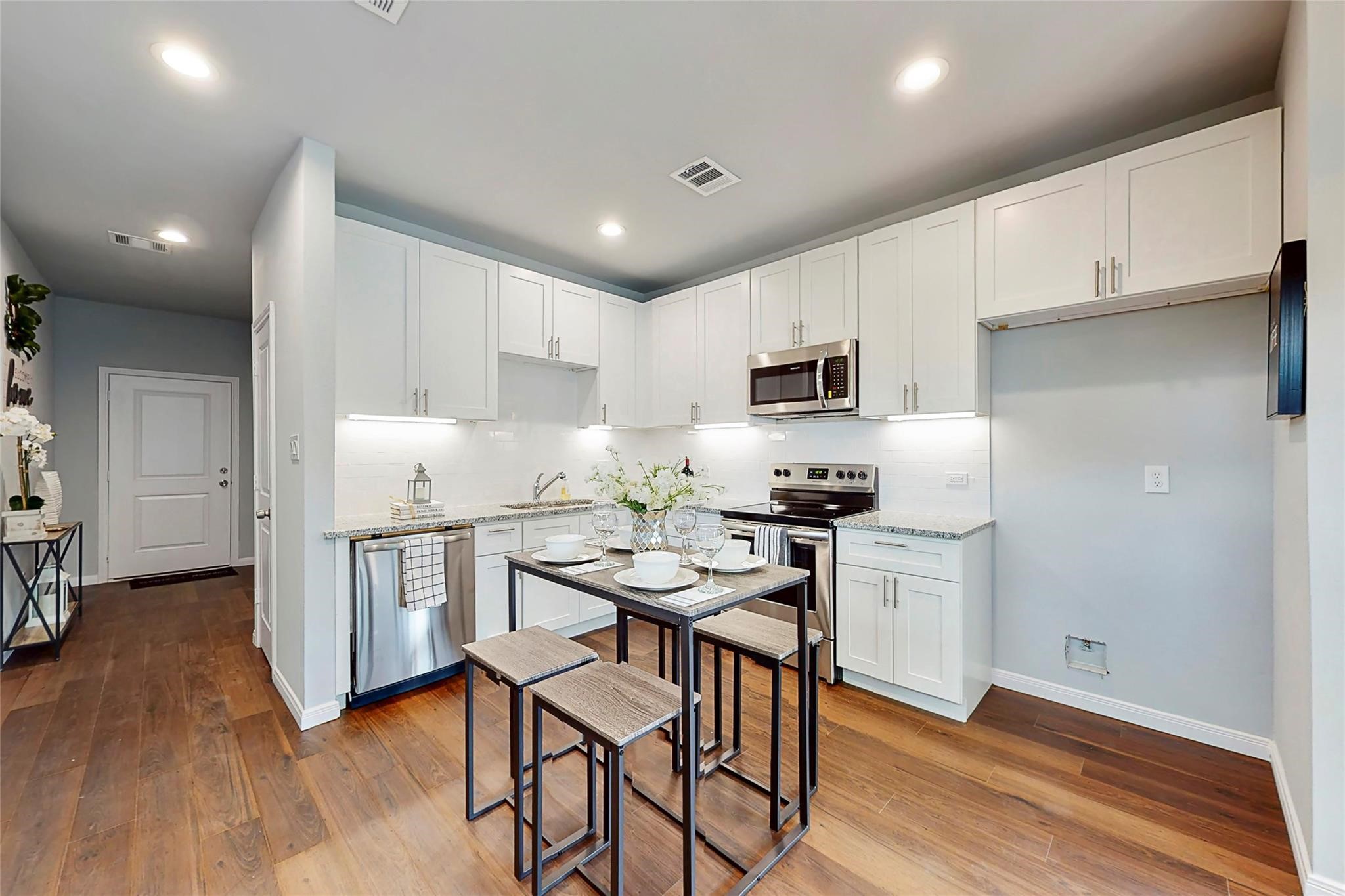 18813 Luminescent Lane Spring, TX 77379 - Photo 4 of 19 a kitchen with white cabinets and stainless steel appliances