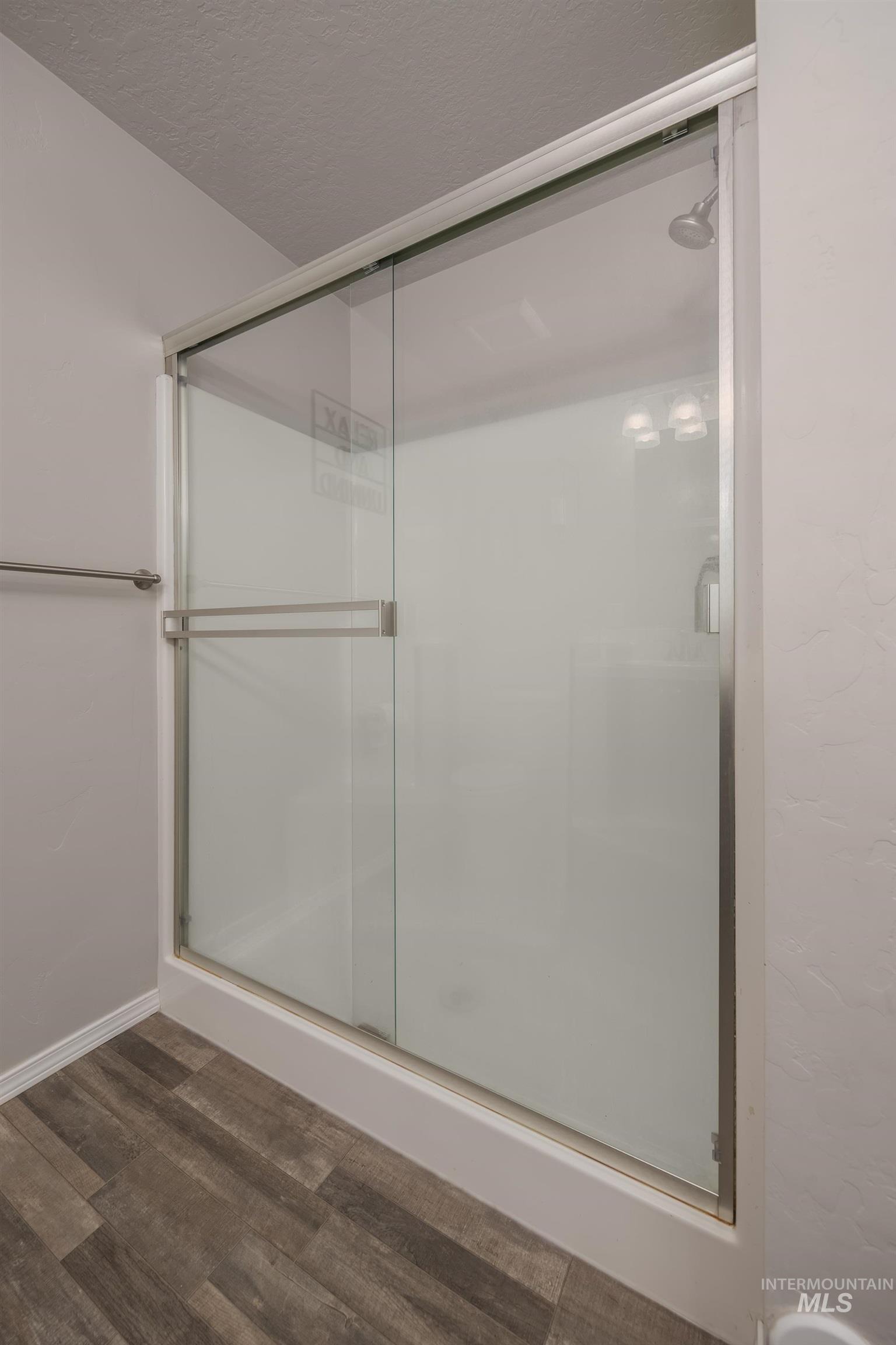 1049 Price Road Weiser, ID 83672 - Photo 18 of 47 Full shower enclosure featuring sliding glass doors, chrome hardware, and a durable white shower base