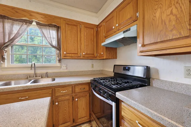 a kitchen with stainless steel appliances granite countertop a sink a stove and a microwave