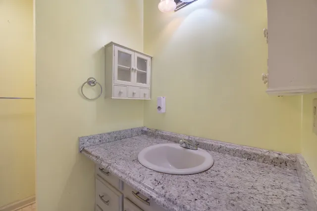 an empty room with wooden floor cabinet and windows