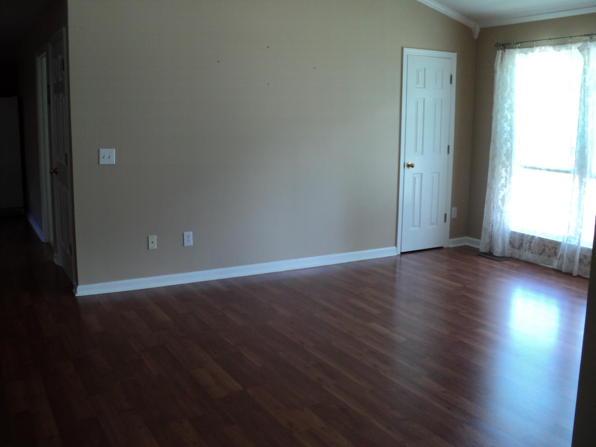 Open space living area w/ laminate flooring.