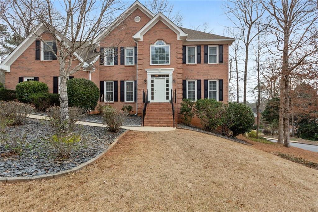 2835 Commons Drive Lawrenceville, GA 30044 - Photo 1 of 1 a front view of a house with yard and trees