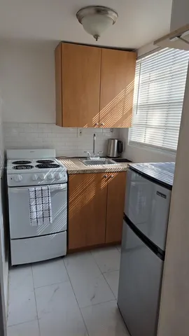 a kitchen with a stove sink and cabinets