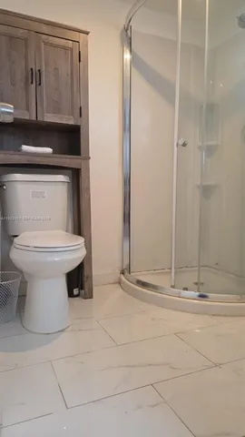 a bathroom with a toilet and a shower