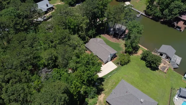 an aerial view of a house with a yard and lake view
