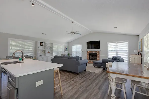 a living room with furniture a flat screen tv and wooden floor