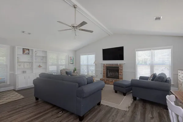 a living room with furniture a fireplace and a flat screen tv