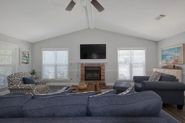 a living room with furniture a fireplace and a flat screen tv