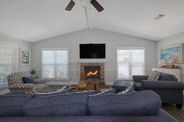 a living room with furniture a fireplace and a flat screen tv