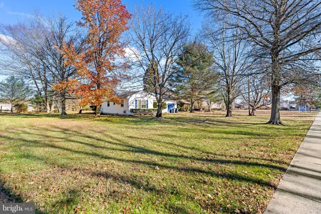 a view of a house with a big yard and large trees