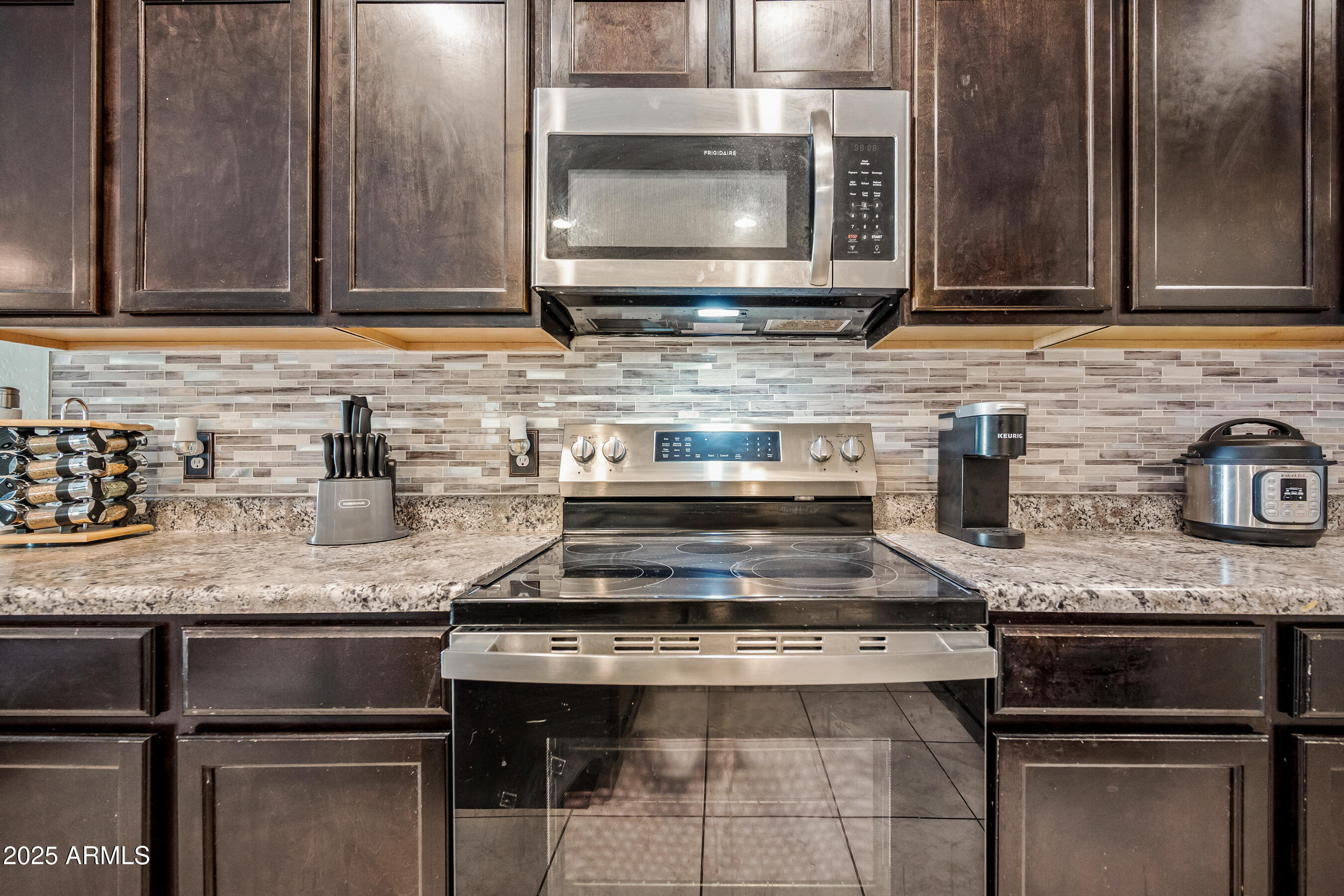 25626 West Coles Road Buckeye, AZ 85326 - Photo 12 of 31 a kitchen with granite countertop a stove microwave and sink