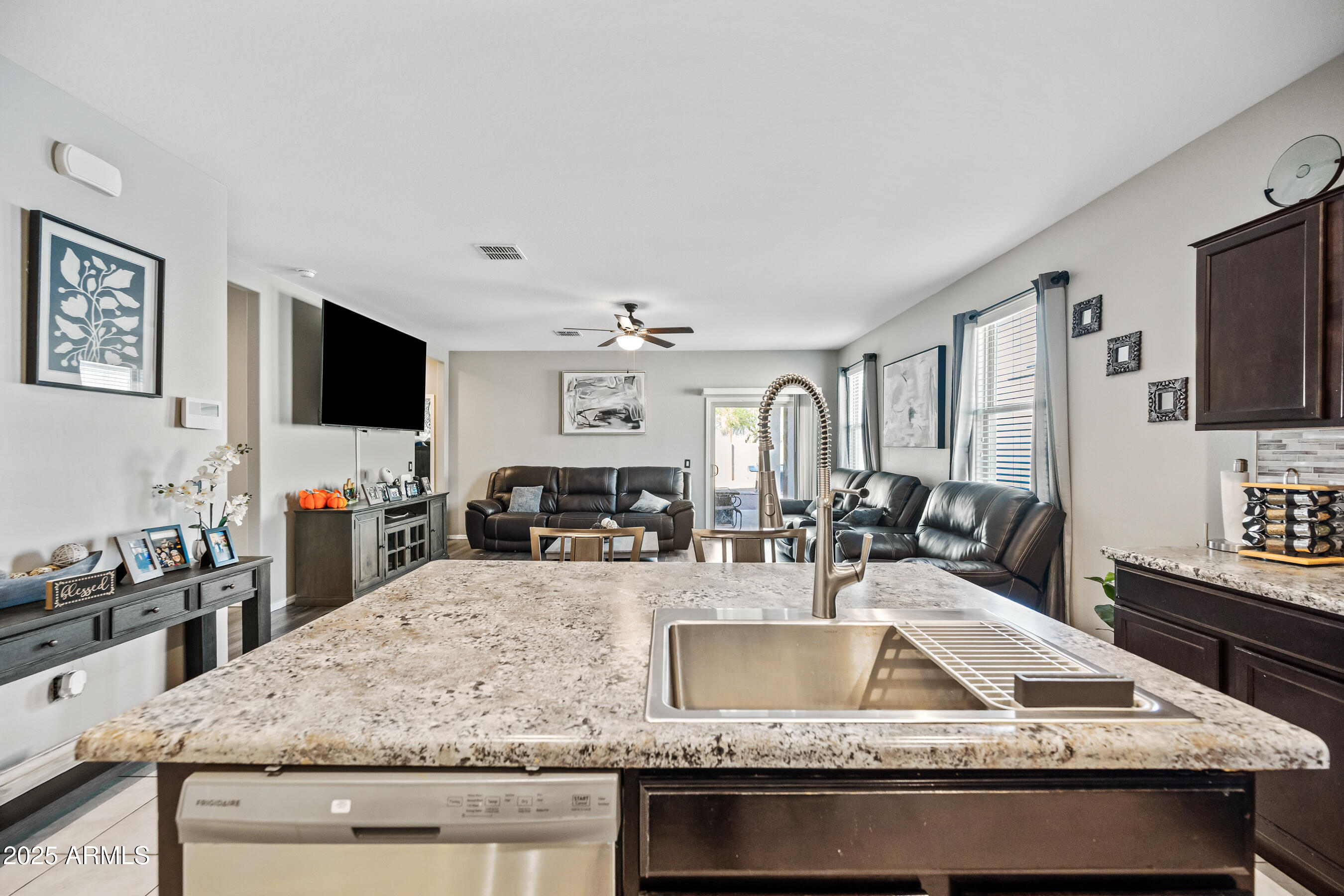25626 West Coles Road Buckeye, AZ 85326 - Photo 16 of 31 a kitchen with kitchen island granite countertop a sink a counter top space appliances and cabinets