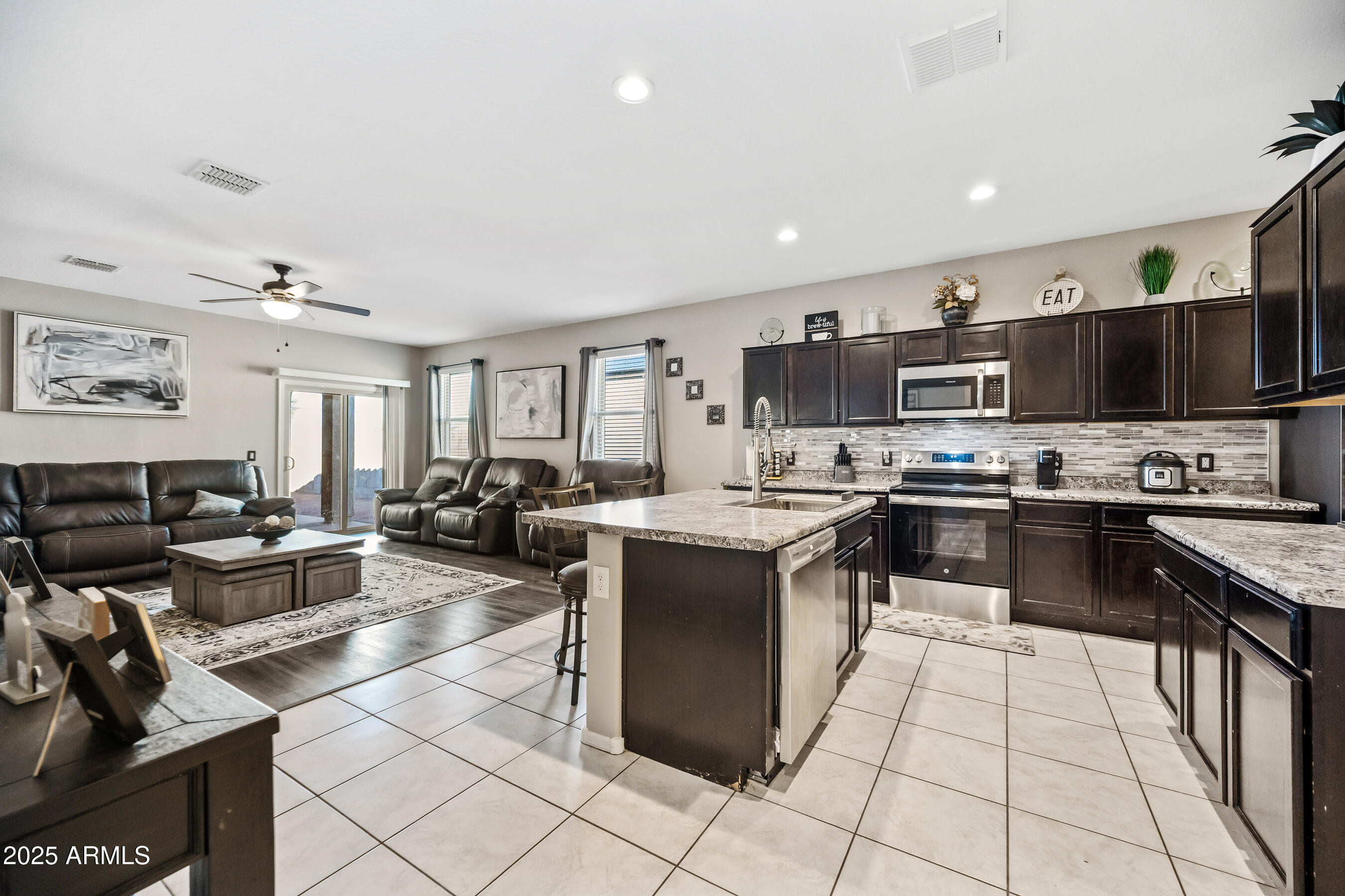 25626 West Coles Road Buckeye, AZ 85326 - Photo 5 of 31 a kitchen with stainless steel appliances kitchen island granite countertop a sink dishwasher stove and cabinets