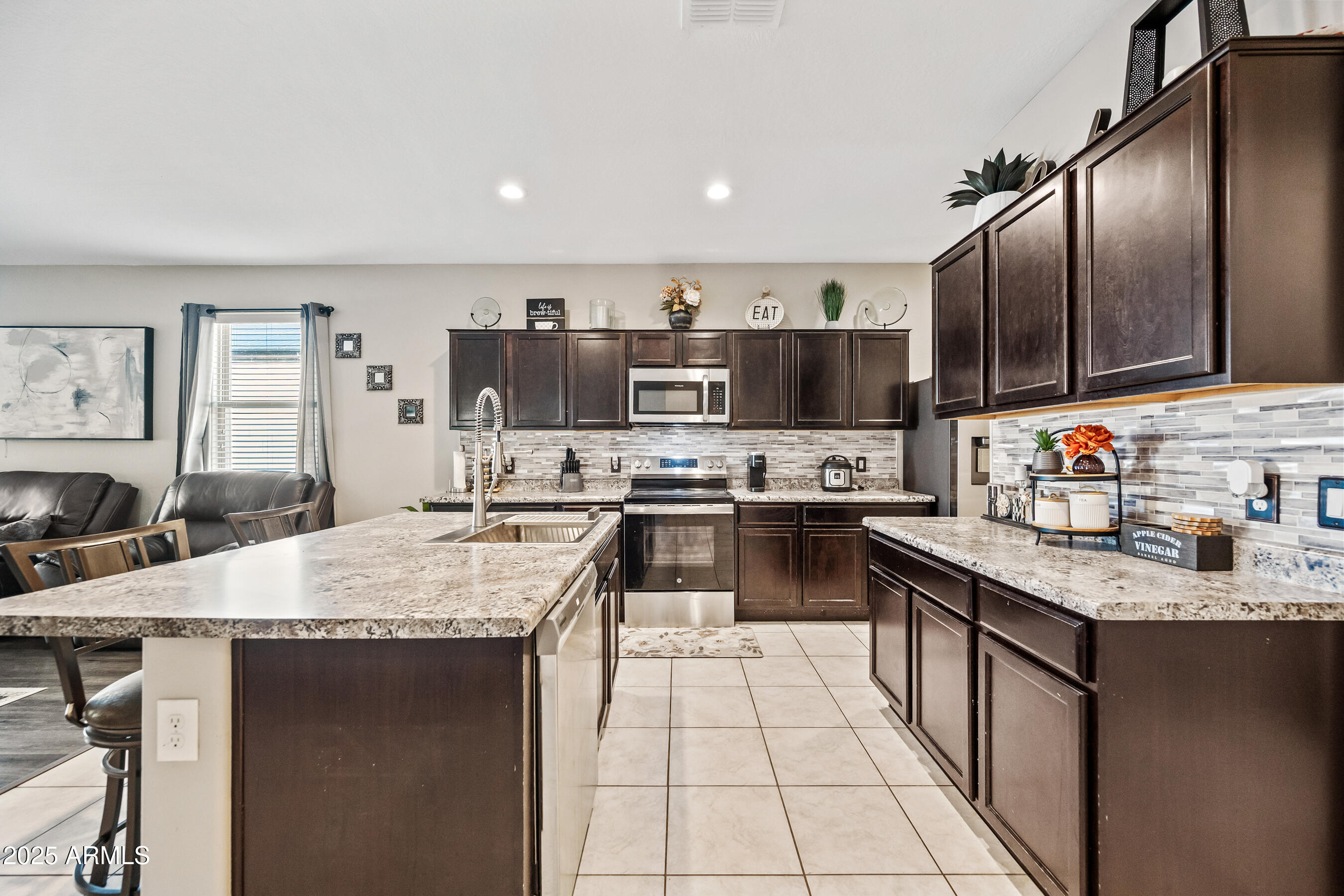 25626 West Coles Road Buckeye, AZ 85326 - Photo 10 of 31 a kitchen with stainless steel appliances granite countertop a sink dishwasher stove refrigerator and cabinets