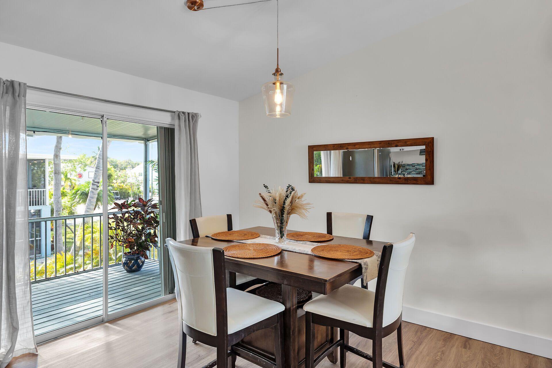 878 La Paloma Road Key Largo, FL 33037 - Photo 11 of 38 a view of a dining room with furniture window and wooden floor