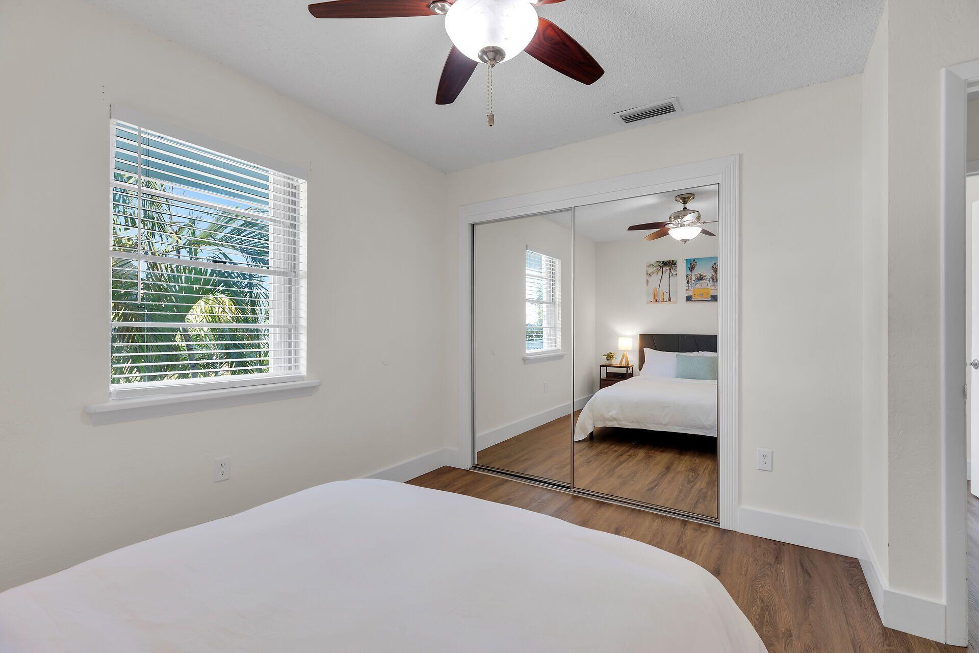 878 La Paloma Road Key Largo, FL 33037 - Photo 23 of 38 a bedroom with a bed and a chandelier