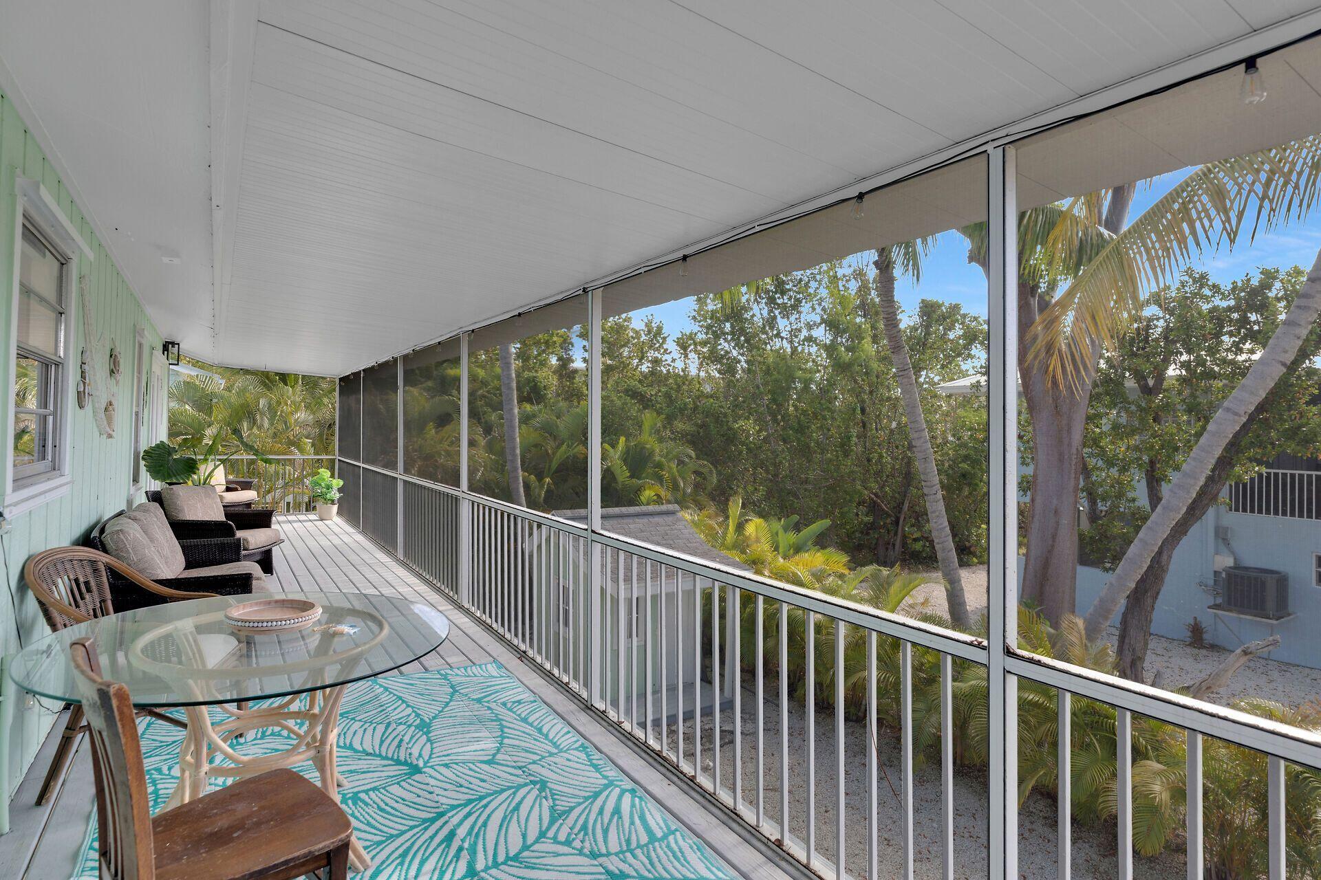 878 La Paloma Road Key Largo, FL 33037 - Photo 5 of 38 a view of a porch with furniture and a yard