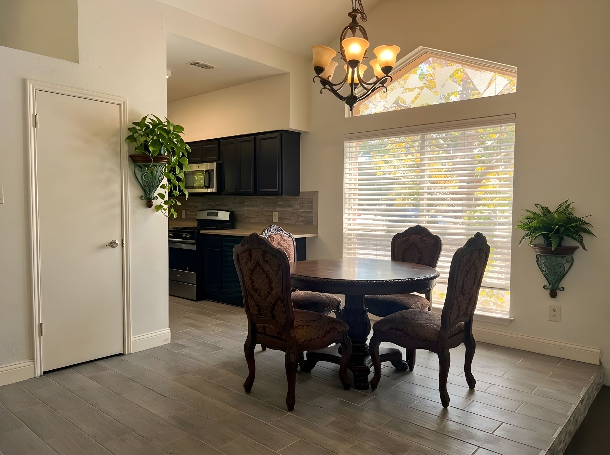 5611 Meadow Crest Austin, TX 78744 - Photo 10 of 29 Virtual Staged, A well-lit dining space featuring durable wood flooring and an elegant chandelier.