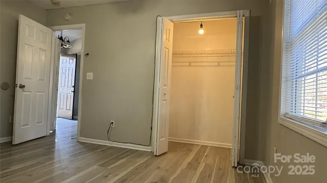 an empty room with wooden floor and a window