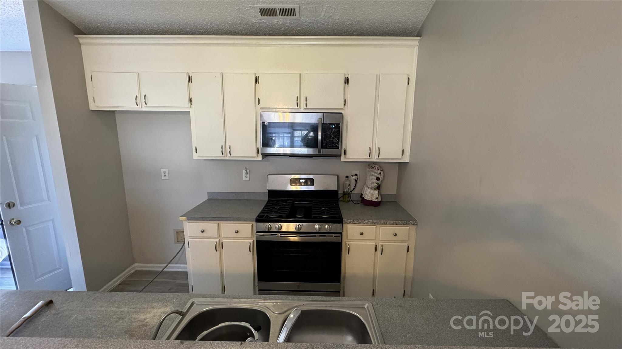 114 South Branch Street Monroe, NC 28112 - Photo 21 of 32 a kitchen with granite countertop white cabinets and black appliances