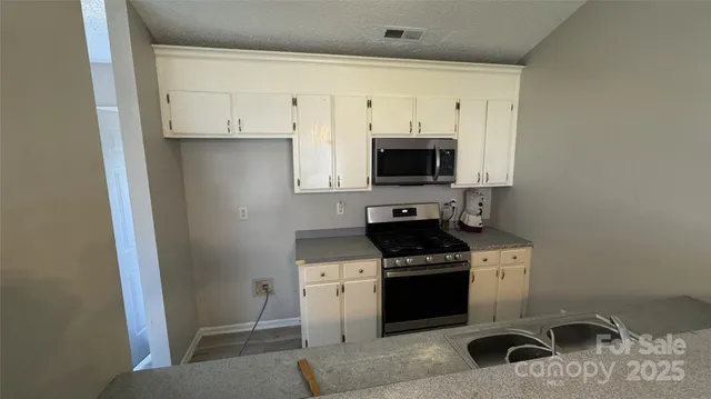 a kitchen with stainless steel appliances a stove a sink and a refrigerator