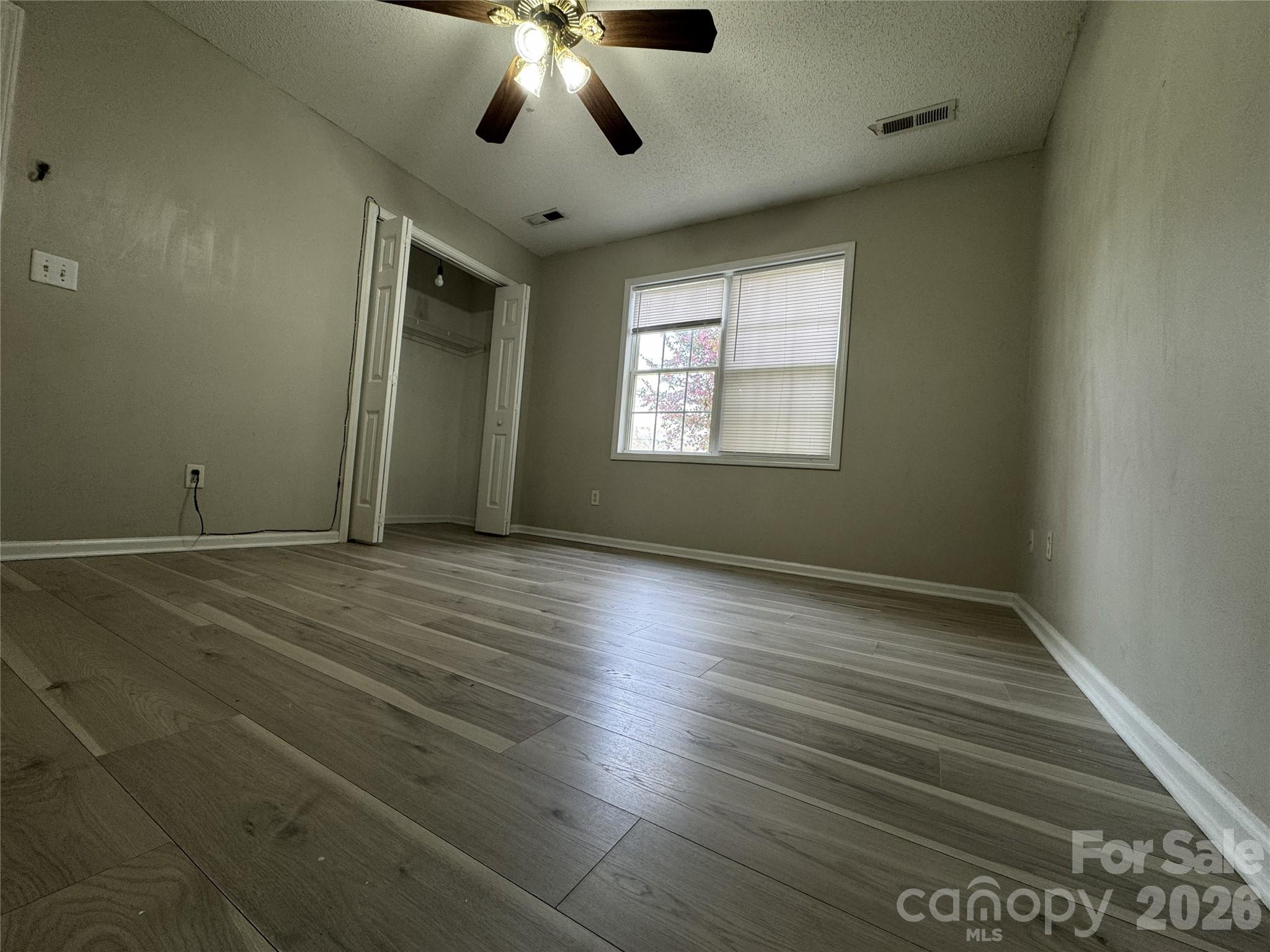 114 South Branch Street Monroe, NC 28112 - Photo 23 of 44 an empty room with wooden floor chandelier fan and windows