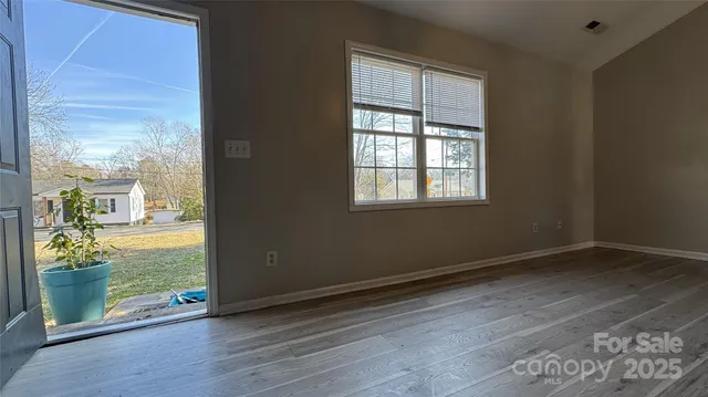 an empty room with wooden floor and a window