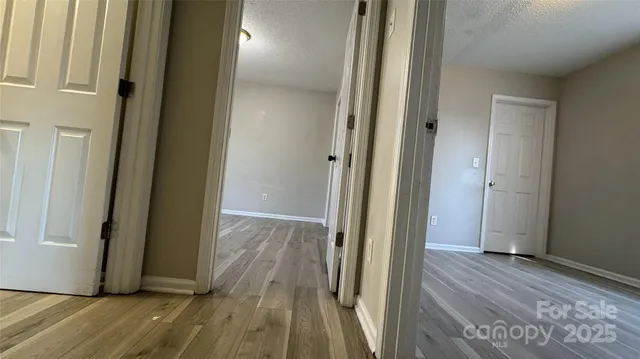 a view of a hallway with wooden floor and staircase