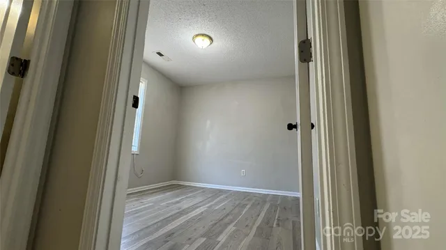 a view of a hallway with wooden floor and closet area