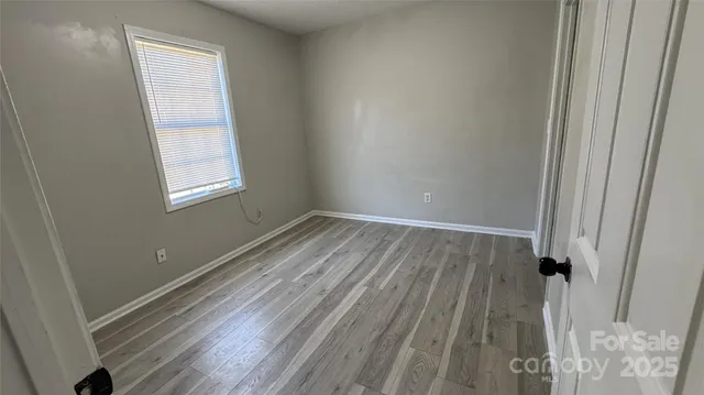 a view of a room with wooden floor and windows