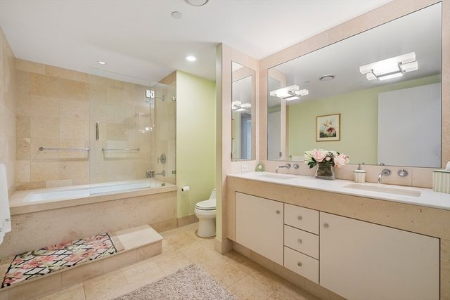 a bathroom with a bathtub shower sink mirror and toilet