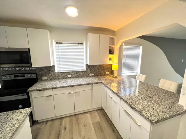 a kitchen with granite countertop a sink and a stove